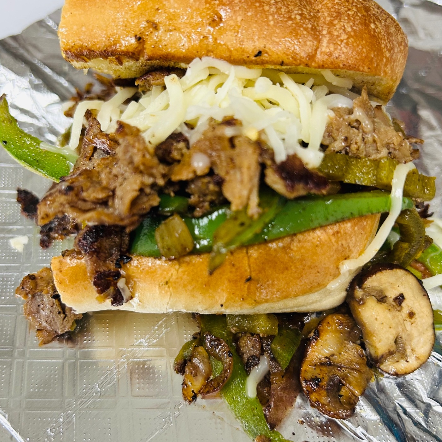 Philly cheesesteak with grilled peppers, mushrooms, onions, and melted cheese